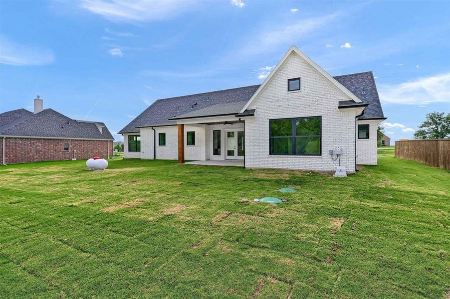 Rear view of house with a patio area and a yard