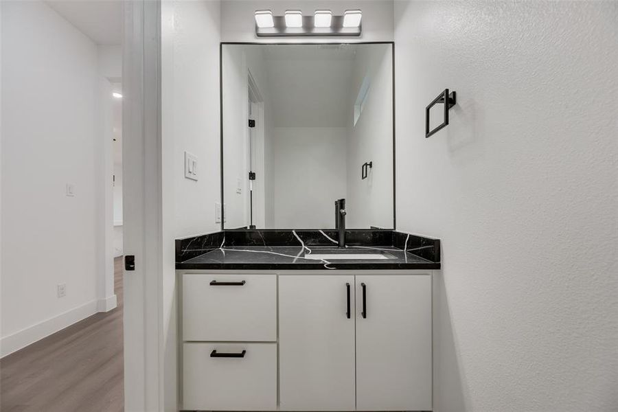 Downstairs half bathroom featuring floating vanity