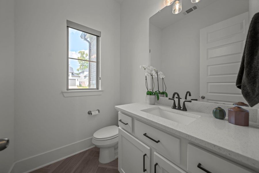 Crisp white powder bath with neutral countertop and modern black fixtures—stylish and guest-ready. Crisp white powder bath with neutral countertop and modern black fixtures—stylish and guest-ready.
