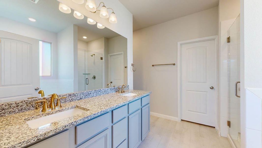 Full bath featuring double vanity and a stall shower