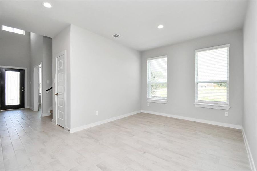 Create lasting memories with your family and friends at the dining table in this expansive dining room.  Showcases sophisticated flooring, custom paint, and seamlessly connects to the family room and kitchen, providing an open and inviting atmosphere. Sample photo of completed home with similar floor plan. As-built interior colors and selections may vary.