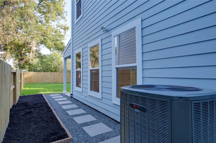 Low-maintenance side yard with paver walkway and gravel border for easy drainage. Fresh mulch bed ready for planting, exterior lighting, and easy access to the covered patio and grassy backyard. Fully fenced for privacy. Top quality Trane HVAC equipment. Low-maintenance side yard with paver walkway and gravel border for easy drainage. Fresh mulch bed ready for planting, exterior lighting, and easy access to the covered patio and grassy backyard. Fully fenced for privacy. Top quality Trane HVAC equipment.