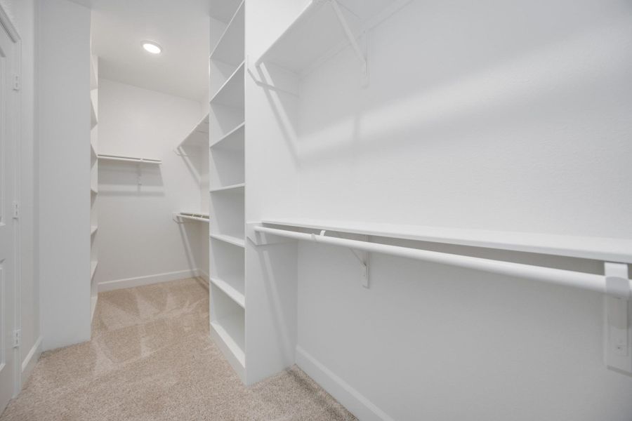 This is just one of two spacious walk-in closets in the primary suite—designed to keep your wardrobe beautifully organized and always within easy reach.