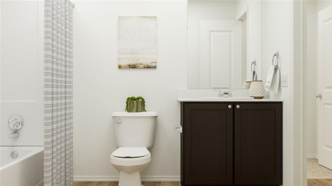 Full bathroom featuring toilet, vanity, shower / bath combo, and hardwood / wood-style flooring