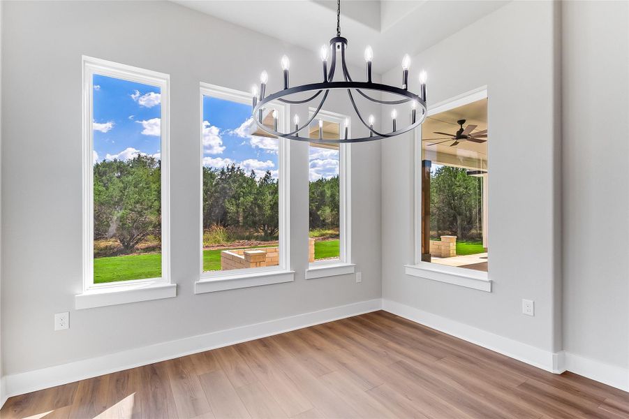 Unfurnished dining area featuring light wood-style floors, ceiling fan, and hanging lights
