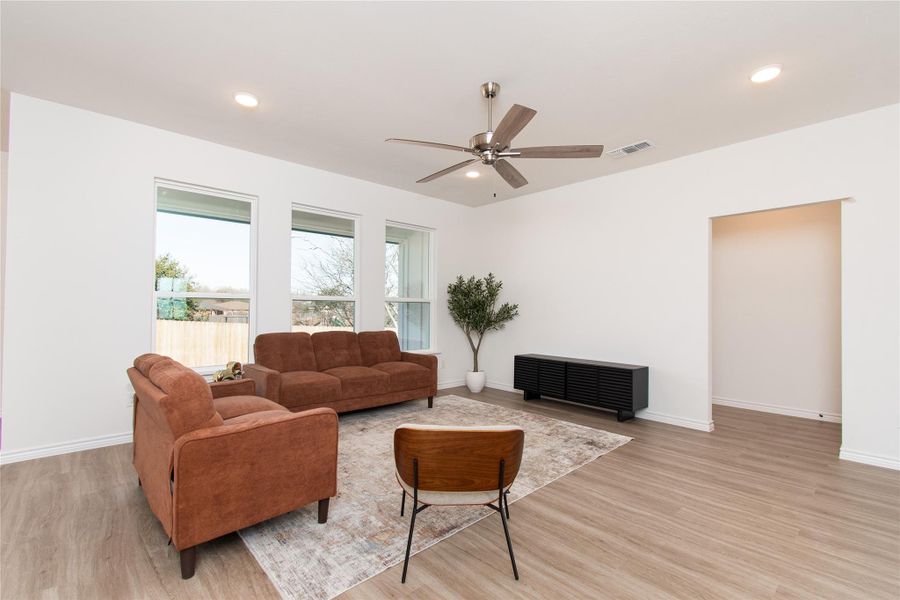 Living room featuring ceiling fan, light wood finished floors, and recessed lighting