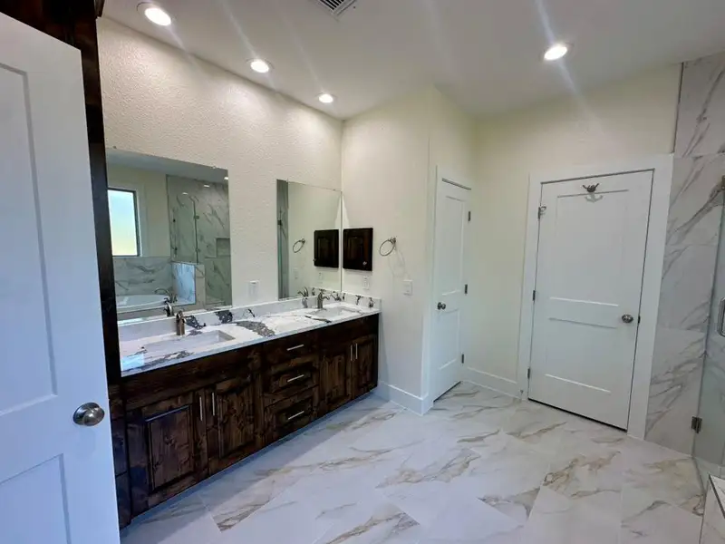 Full bath with a garden tub, a marble finish shower, double vanity, light marble finish flooring, and recessed lighting