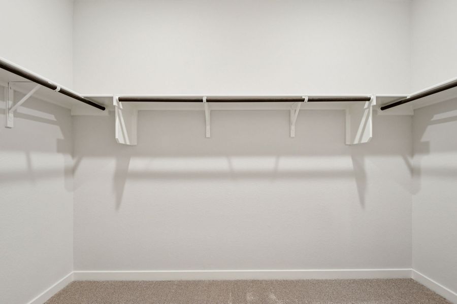 A white wall with a metal bar.