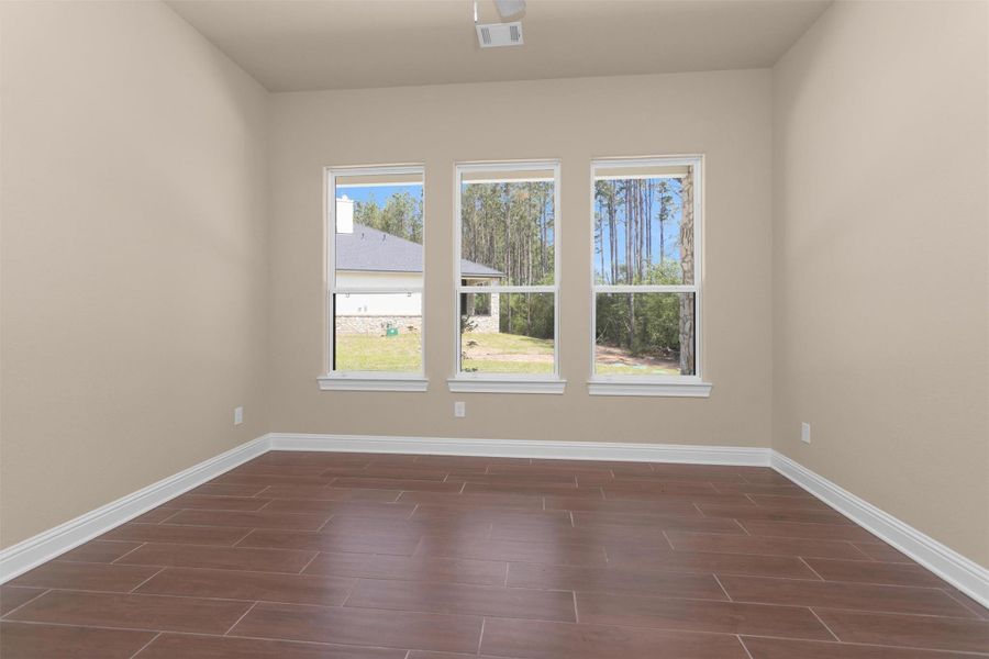 The second bedroom in the guest house features three large windows that bring in tons of natural light and wood-look tile flooring. The second bedroom in the guest house features three large windows that bring in tons of natural light and wood-look tile flooring.