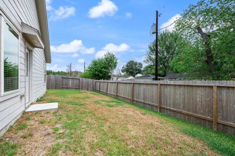 Spacious fenced backyard offers an open lawn area with direct access to the home, providing flexible space for outdoor activities. Spacious fenced backyard offers an open lawn area with direct access to the home, providing flexible space for outdoor activities.