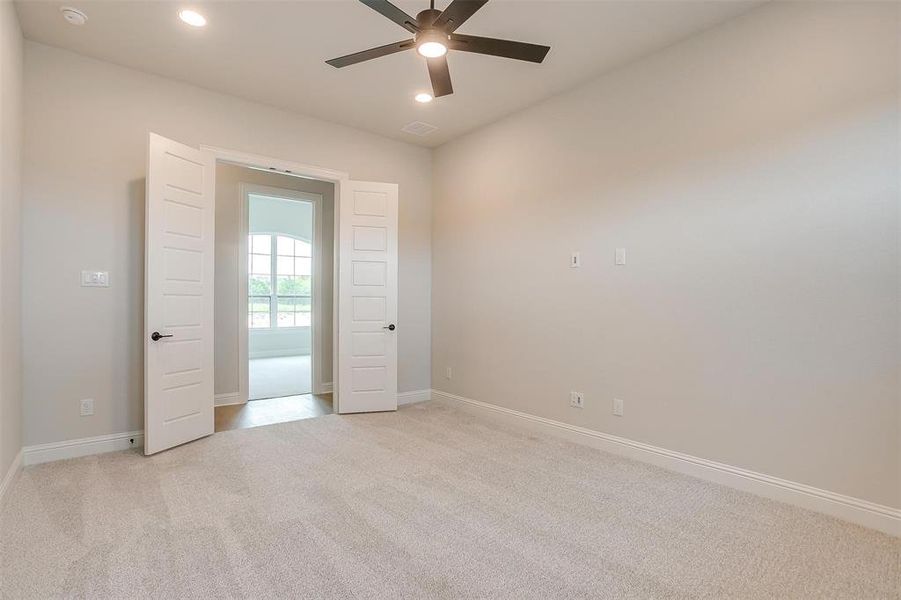 Carpeted spare room with ceiling fan