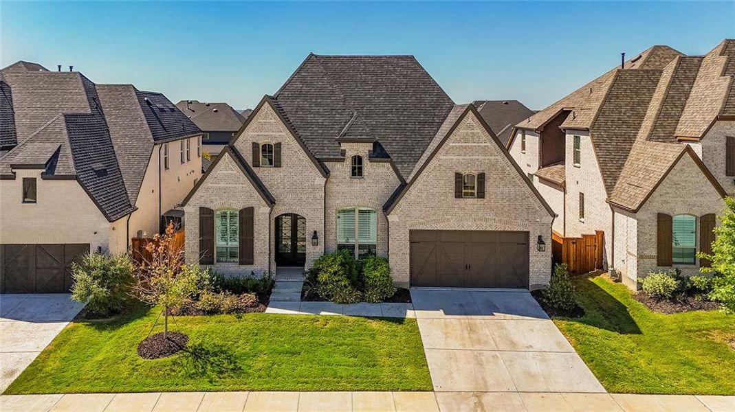 View of front of home with a front yard and a garage