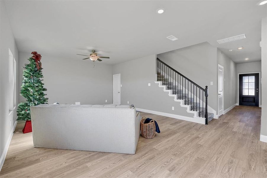 Living room with ceiling fan and light hardwood / wood-style floors