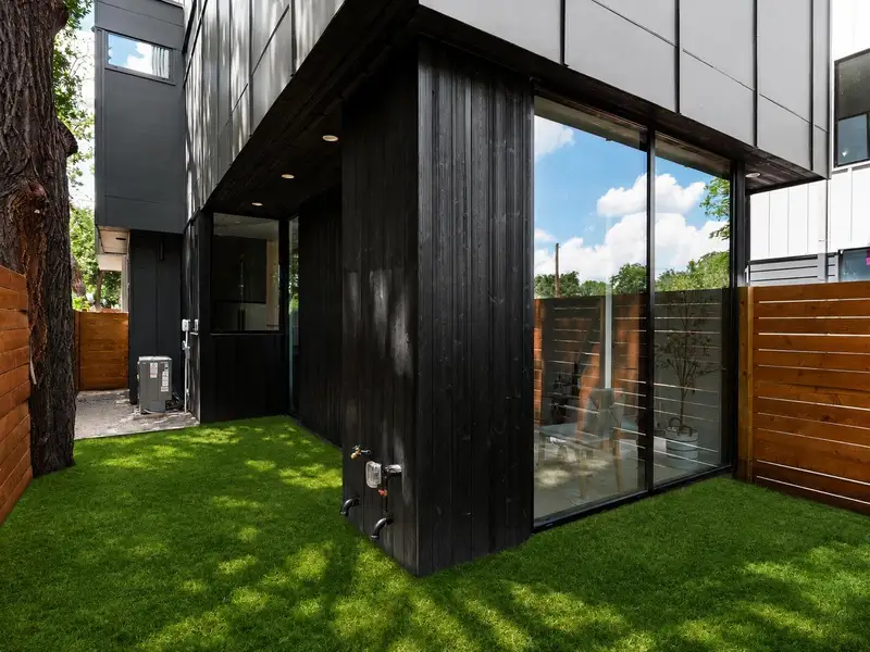 A lawn wraps around the modern facade of this striking residence, bordered by a tasteful wooden fence. Gas and water hookups ready for outdoor grill A lawn wraps around the modern facade of this striking residence, bordered by a tasteful wooden fence. Gas and water hookups ready for outdoor grill