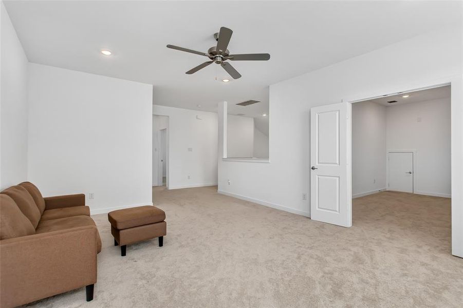 Carpeted room with a contemporary ceiling fan and recessed lighting