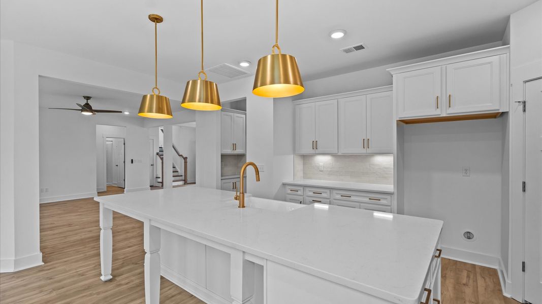 Exclusive DRB Homes kitchen with a 10-foot island, elevated finishes, and pendant lighting in a prime location