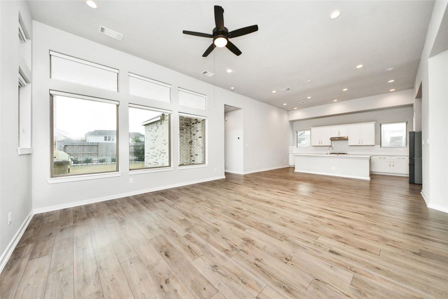 Expansive living room with large windows and ceiling fan