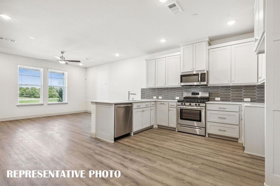 Light, bright and airy, this open concept kitchen-dining-family room is everything you have been searching for in a look and leave lifestyle home!  REPRESENTATIVE PHOTO