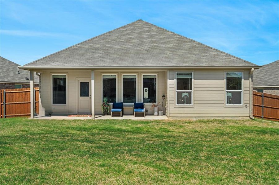 Rear view of property featuring a patio area, a fenced backyard, and roof with shingles Rear view of property featuring a patio area, a fenced backyard, and roof with shingles