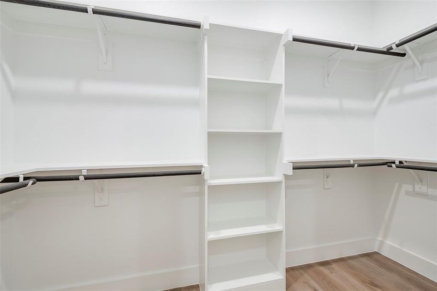 Walk in closet with light wood-type flooring