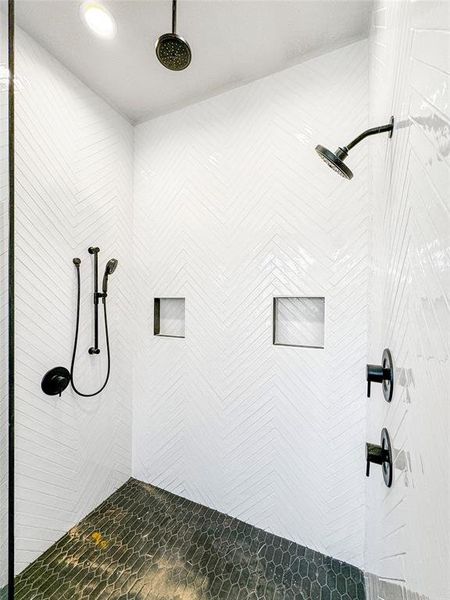 Indulge in the opulence of the Primary Shower, adorned with meticulously arranged herringbone-styled tiles, creating an artful and sophisticated atmosphere. Enhancing your shower experience are three strategically positioned shower heads, providing a lavish and rejuvenating escape.