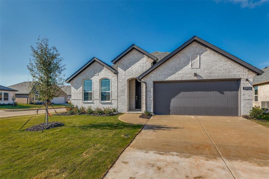 Premium Lot! French country inspired facade with central AC unit, a front lawn, and a garage