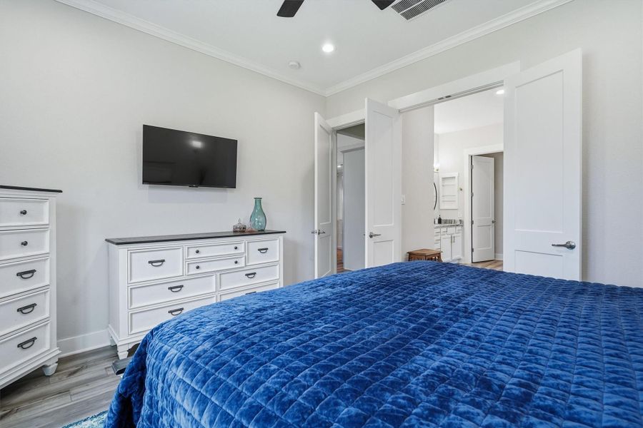 Primary bedroom with ceiling fan, en suite bath and crown molding Primary bedroom with ceiling fan, en suite bath and crown molding