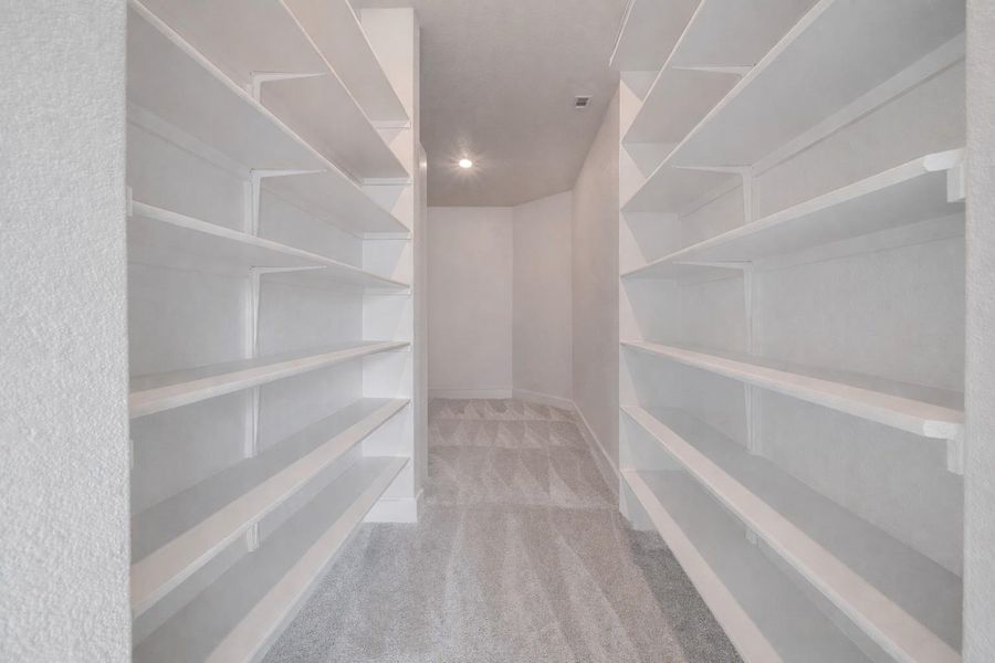 This space features extensive white shelving units, providing ample storage solutions