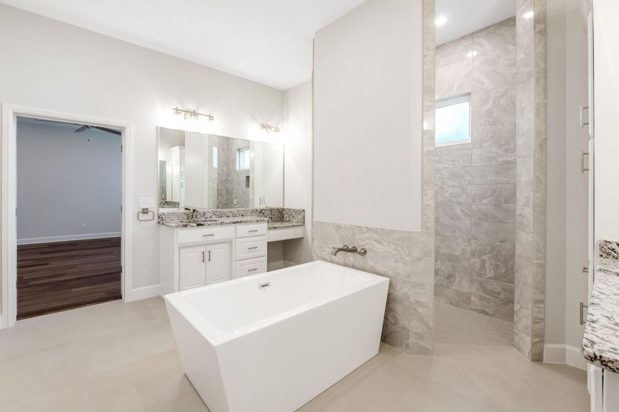 Full bath featuring vanity, a soaking tub, and a walk in shower