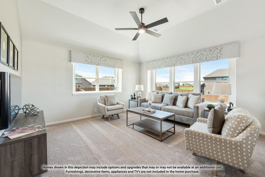 Living room with gray sofa, ceiling fan, carpet flooring, and large windows with neighborhood views Living room with gray sofa, ceiling fan, carpet flooring, and large windows with neighborhood views