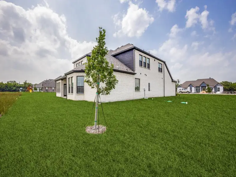 View of side of home with a yard and brick siding View of side of home with a yard and brick siding
