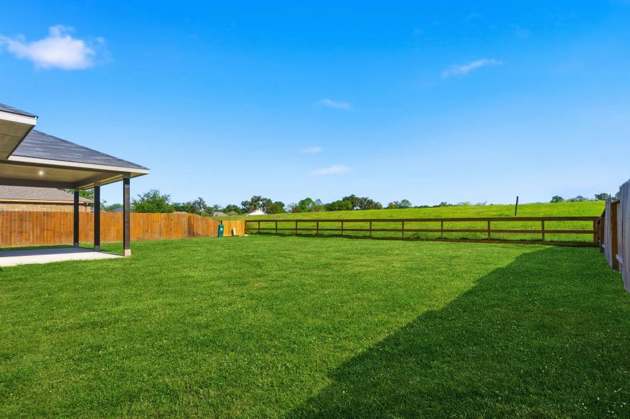 Expansive backyard retreat with lush green space, perfect for playtime, gardening, or future outdoor upgrades. Enjoy the open skies and tranquil atmosphere right from your own property!