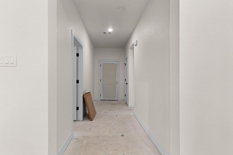 Hall featuring unfinished concrete flooring and baseboards Hall featuring unfinished concrete flooring and baseboards