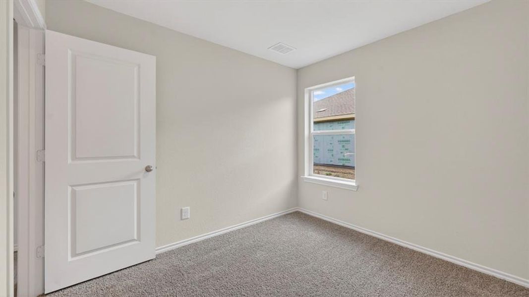 Neutral-toned interior room featuring light gray walls, plush gray carpeting, and white baseboards