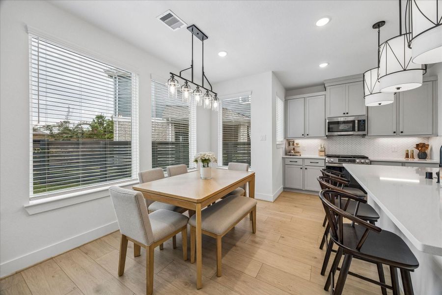 Enjoy meals around the table beneath a modern chandelier, with seamless flow into the kitchen area for effortless everyday living and entertaining.
