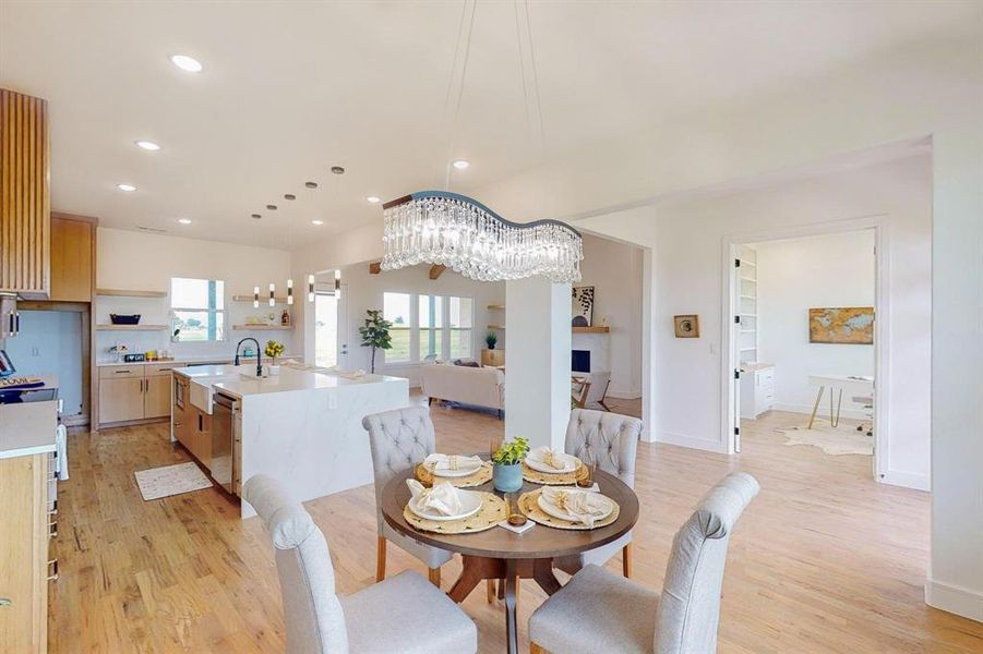 Dining room with a chandelier, light hardwood / wood-style flooring, and sink