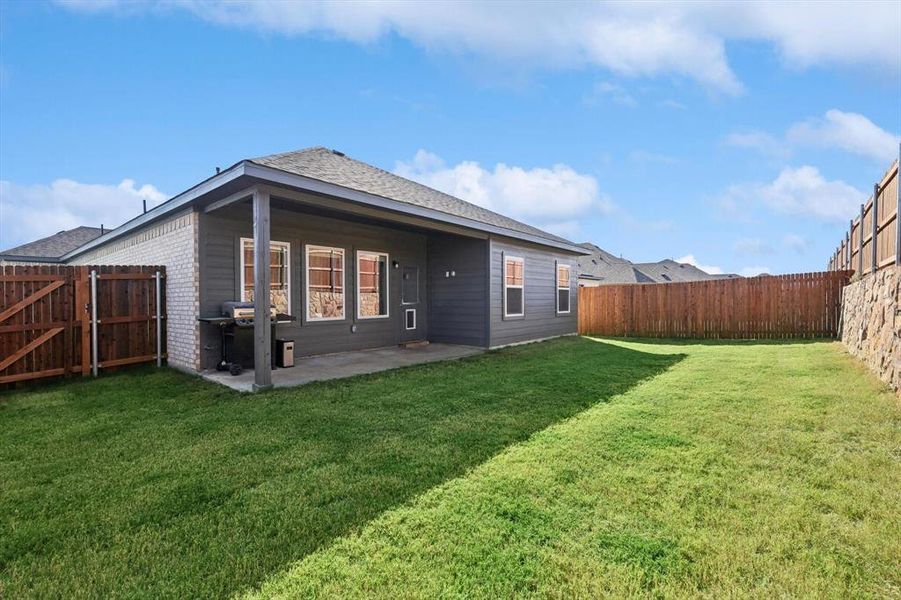 Rear view of property featuring a patio area and a lawn