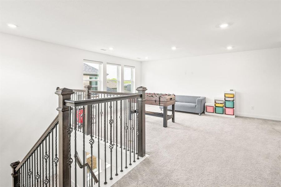 Hallway featuring an upstairs landing, light colored carpet, and recessed lighting