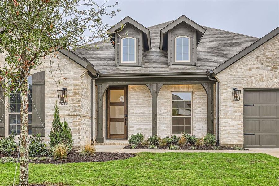 Property entrance featuring a garage and a lawn