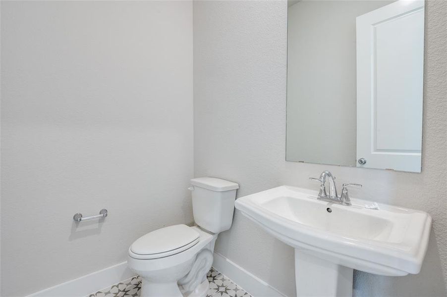 Bathroom with tile patterned floors, sink, and toilet