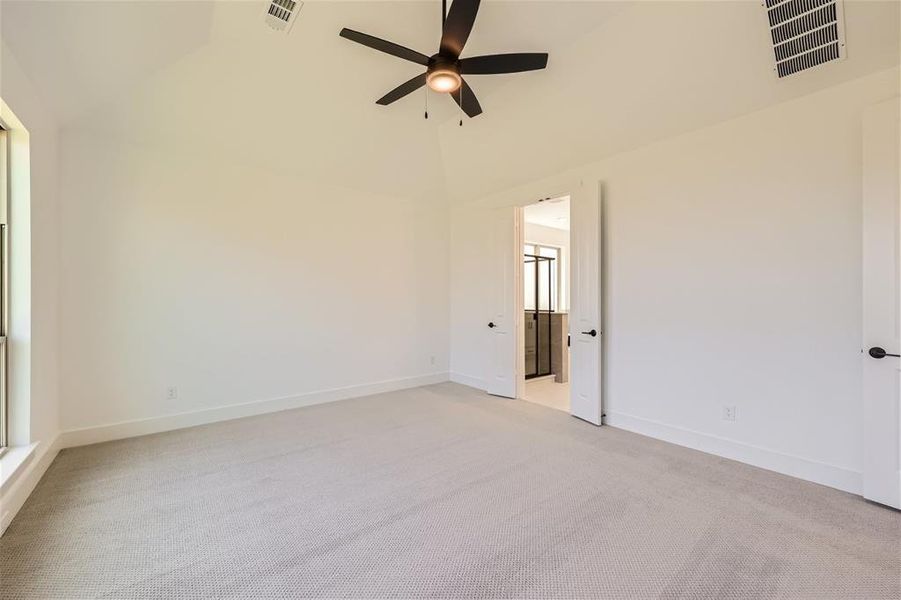 Spare room with light carpet, ceiling fan, and high vaulted ceiling