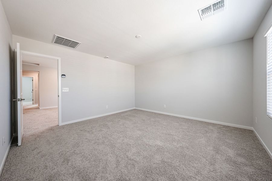 A room with a carpet and a vent.