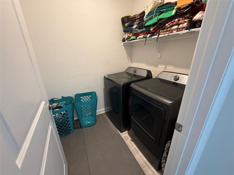 Dedicated laundry area featuring a built-in shelf and tile flooring