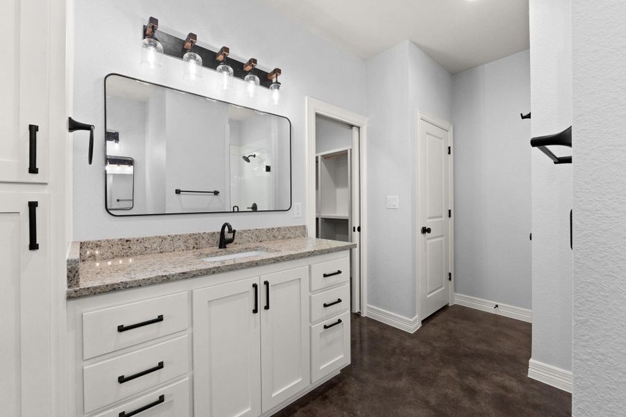 Full bathroom with vanity, finished concrete floors, and a shower