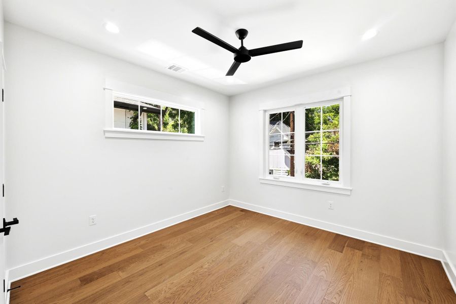 Hardwood floors and generous windows elevate this naturally illuminated bedroom. Hardwood floors and generous windows elevate this naturally illuminated bedroom.