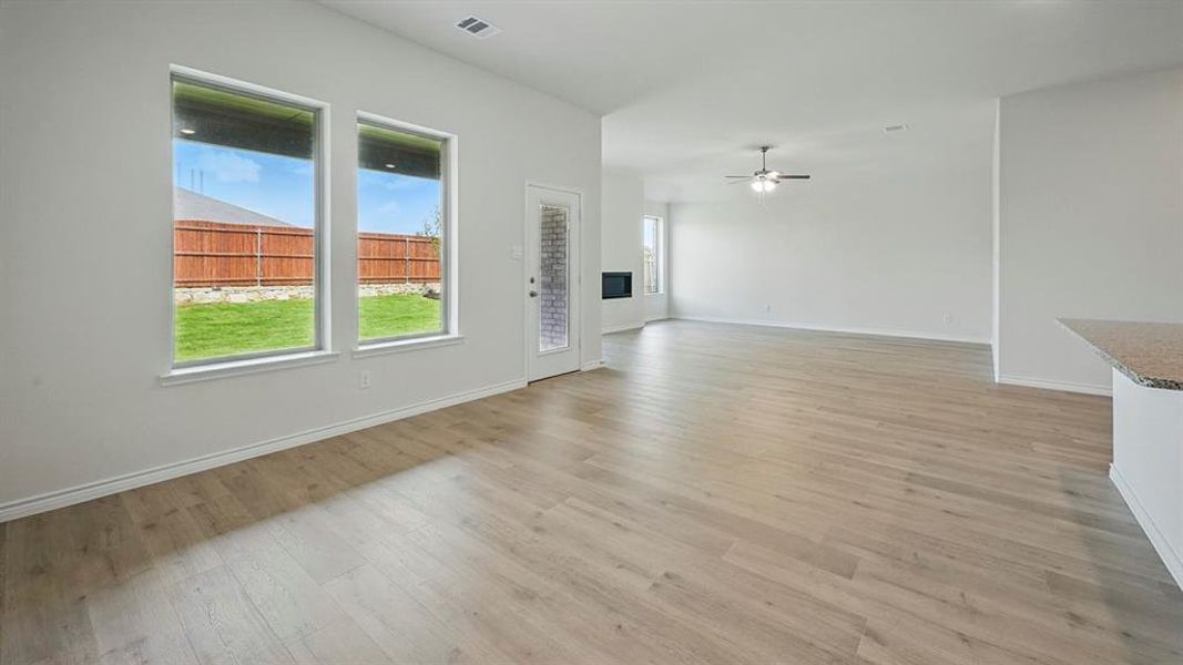 Unfurnished living room featuring light wood-type flooring and a ceiling fan