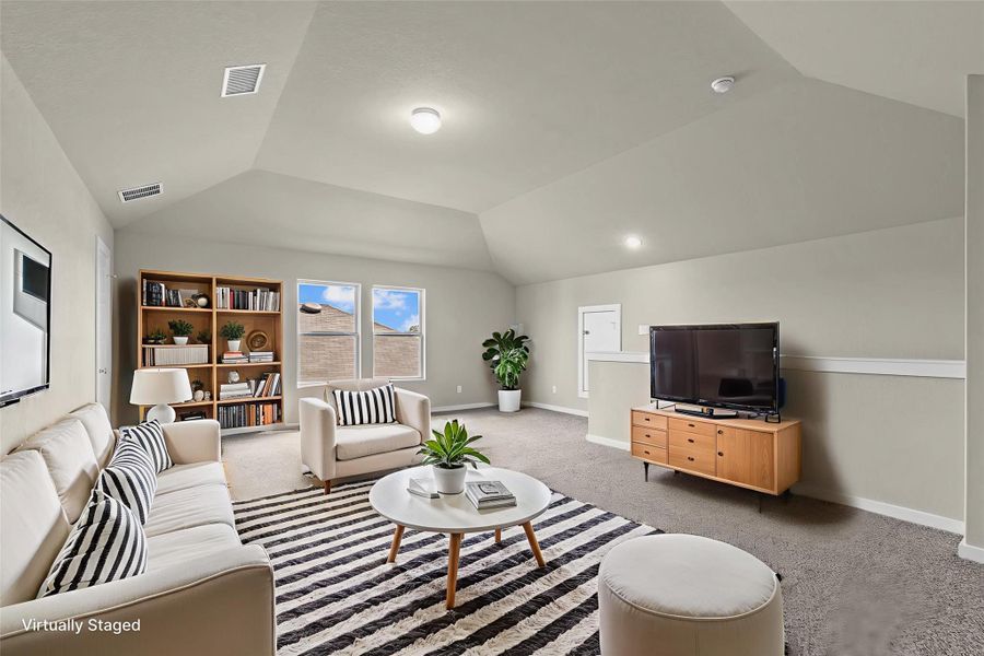 A well-lit bonus room features a vaulted ceiling, providing an ideal flexible living space.