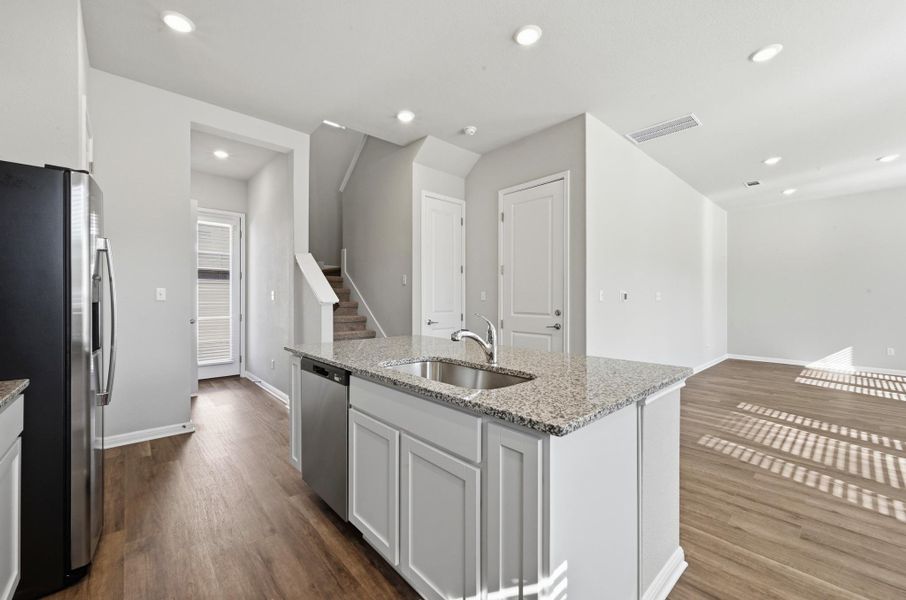 Kitchen island with granite-finish countertop, undermount sink, and stainless steel dishwasher Kitchen island with granite-finish countertop, undermount sink, and stainless steel dishwasher