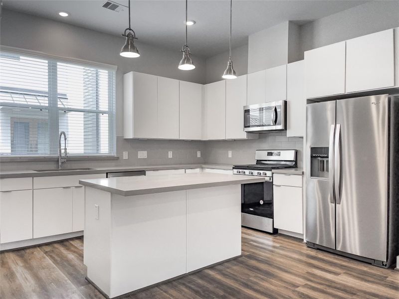 Modern second-floor kitchen with sleek cabinetry, stainless steel appliances, and ample natural light.