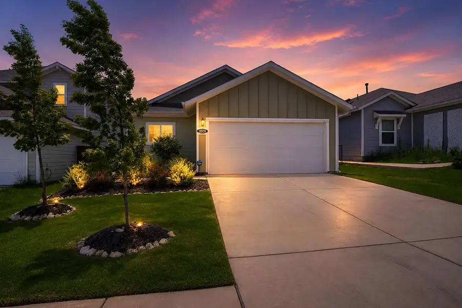 Illuminated landscaping enhances this home's inviting facade, with a dramatic sunset painting the sky. Illuminated landscaping enhances this home's inviting facade, with a dramatic sunset painting the sky.